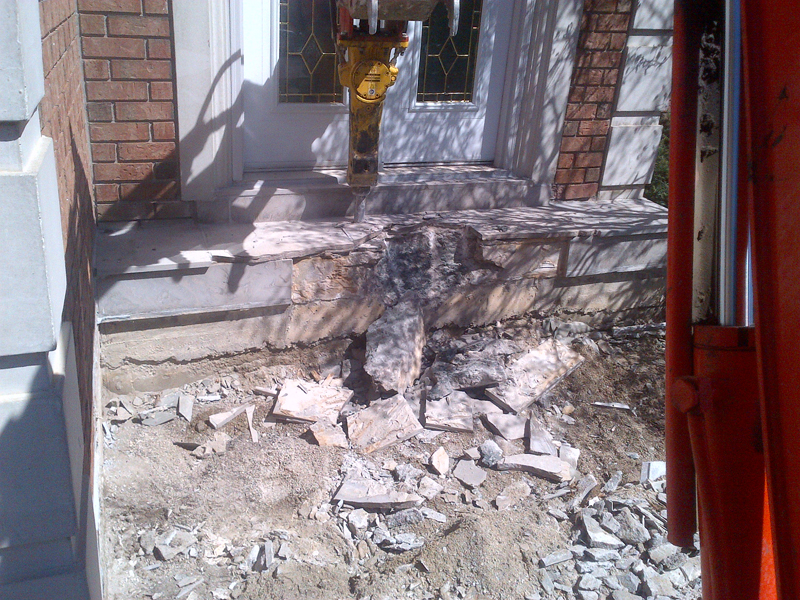 Concrete breaker attachment removing a residential slab