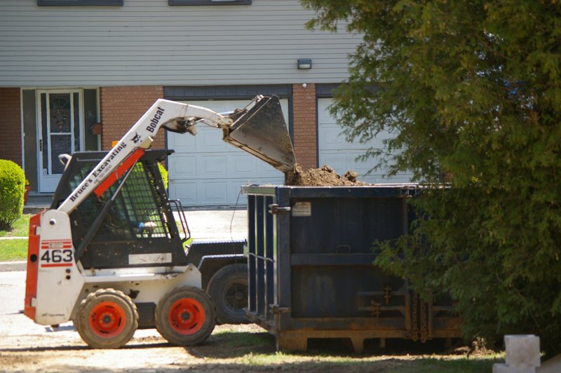 Emptying excavated soil into a loading bin