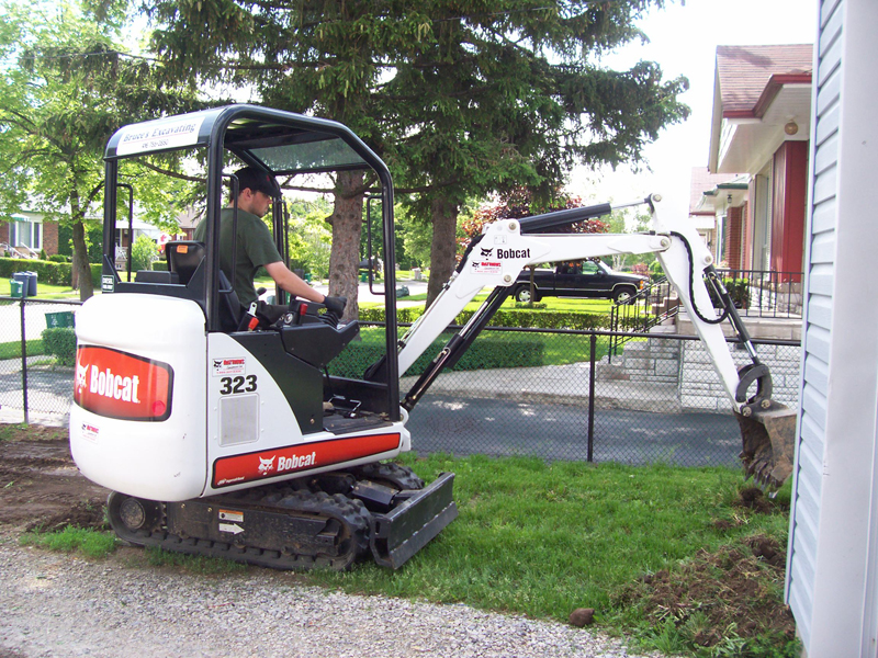 Bobcat removing grass and topsoil during site prep
